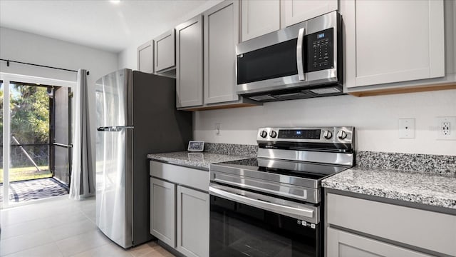 2784 Dode Ave, North Port, FL 34288 - kitchen with appliances with stainless steel finishes, gray cabinets, light stone counters, and light tile patterned flooring