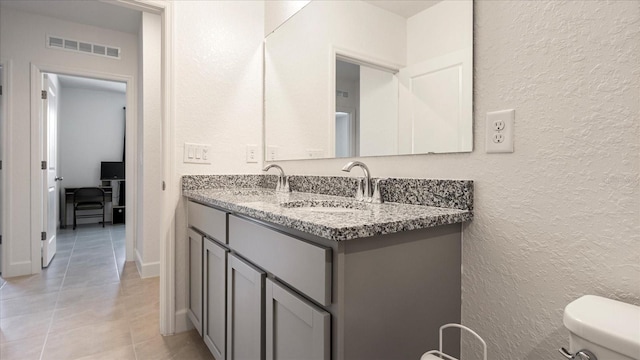 2784 Dode Ave, North Port, FL 34288 - bathroom featuring a textured wall, double vanity, and tile patterned flooring
