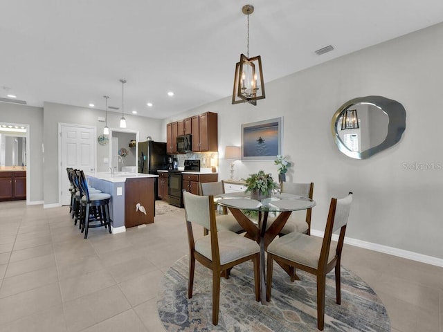 tiled dining room featuring an inviting chandelier and sink