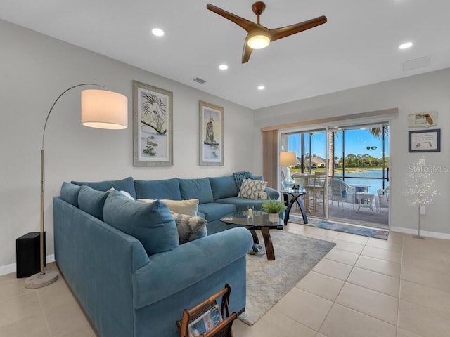 living room featuring light tile patterned floors, a water view, and ceiling fan