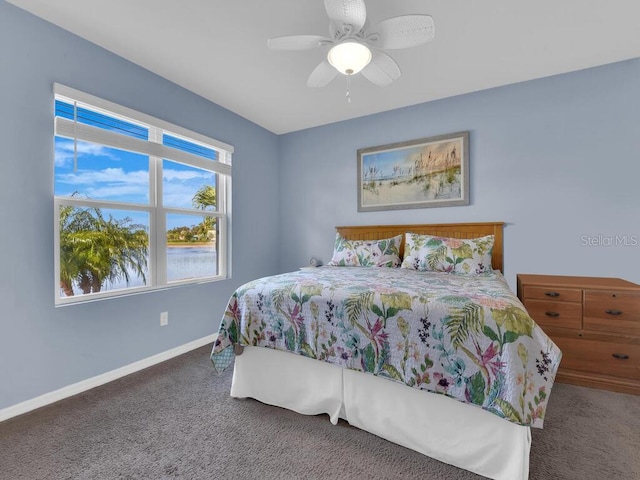 bedroom with ceiling fan and dark colored carpet