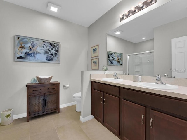 bathroom with tile patterned flooring, vanity, toilet, and a shower with shower door