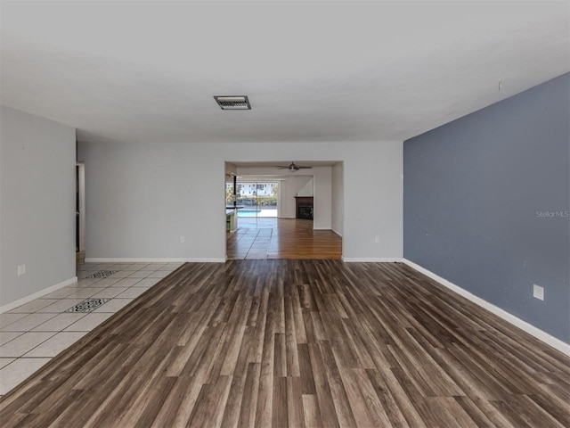 unfurnished living room with wood-type flooring and ceiling fan