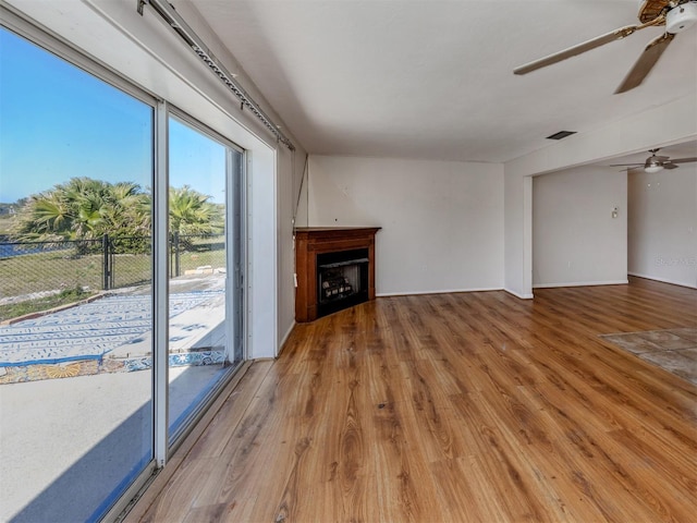 unfurnished living room with ceiling fan and wood-type flooring