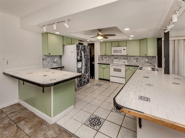 kitchen with sink, green cabinetry, light tile patterned floors, kitchen peninsula, and white appliances