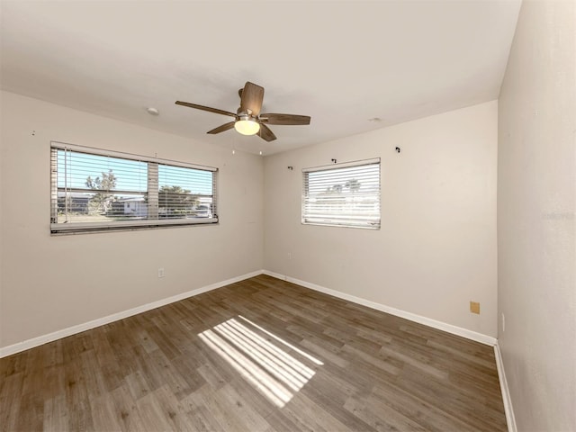 spare room featuring dark wood-type flooring and ceiling fan