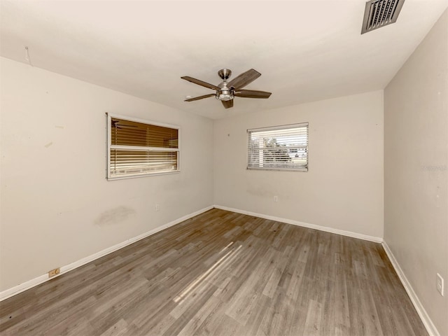 empty room with dark wood-type flooring and ceiling fan