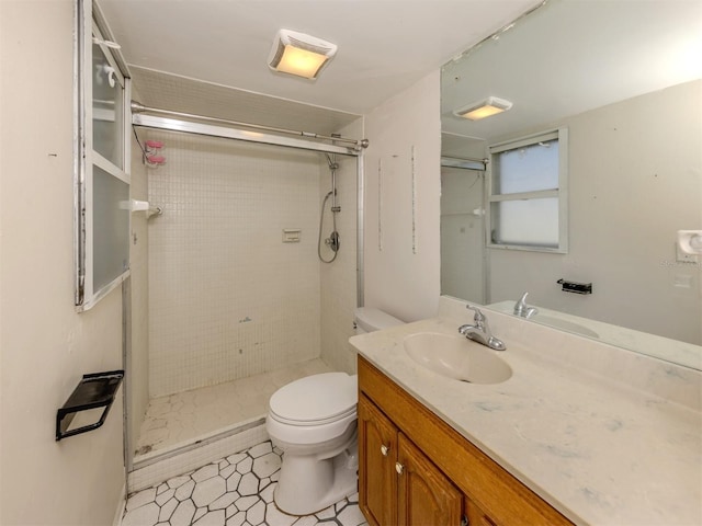 bathroom featuring a shower with door, vanity, and toilet