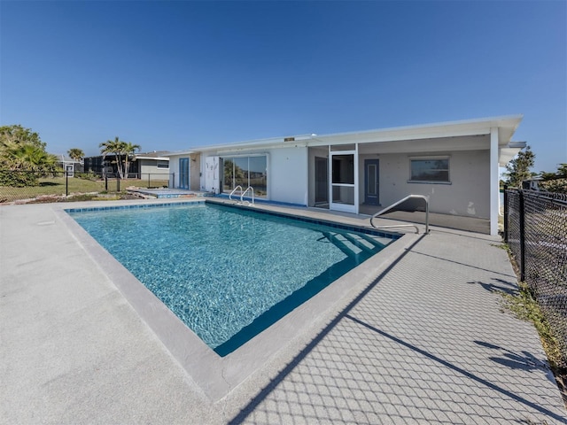 view of swimming pool featuring a jacuzzi and a patio area