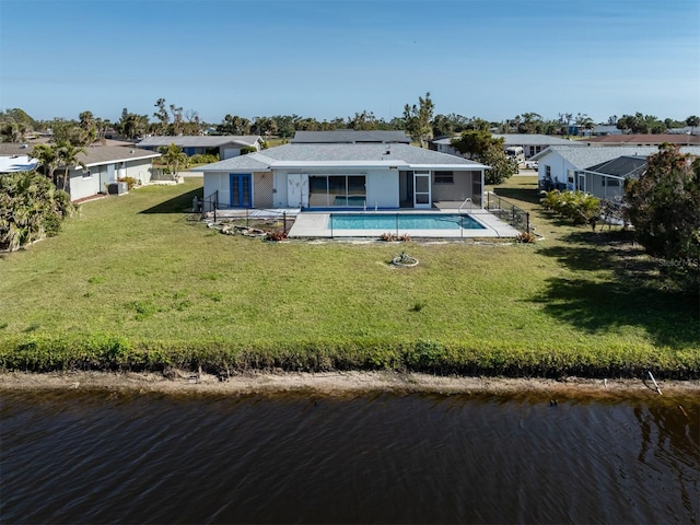 back of house with a yard, a patio area, central air condition unit, and a water view