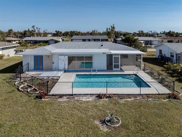 rear view of property with a yard, a fenced in pool, and a patio area