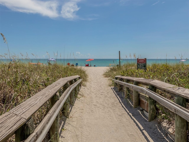 view of property's community featuring a beach view and a water view