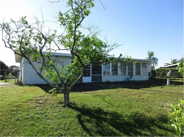 view of front facade with a sunroom and a front lawn