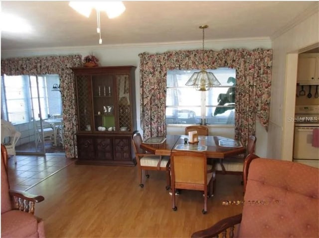 dining space featuring hardwood / wood-style flooring and ornamental molding