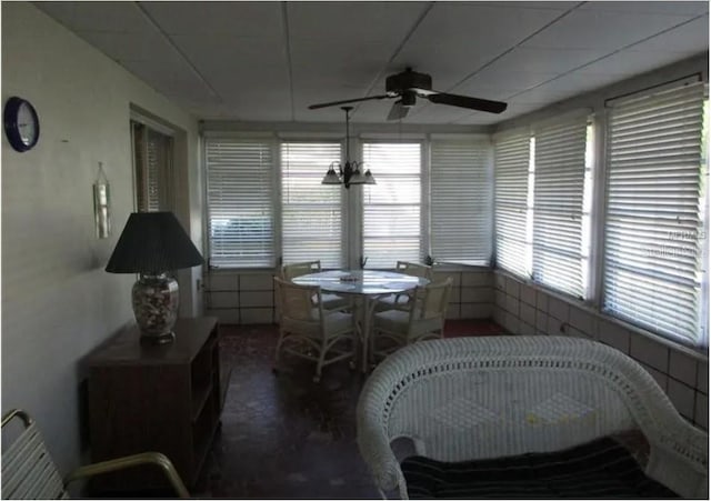 sunroom / solarium featuring ceiling fan with notable chandelier