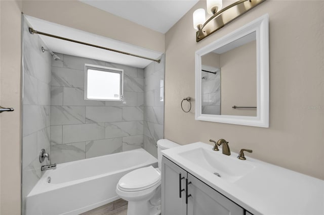 full bathroom featuring vanity, hardwood / wood-style flooring, tiled shower / bath, and toilet