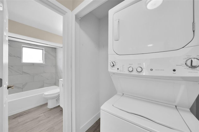 washroom featuring light hardwood / wood-style floors and stacked washer and clothes dryer