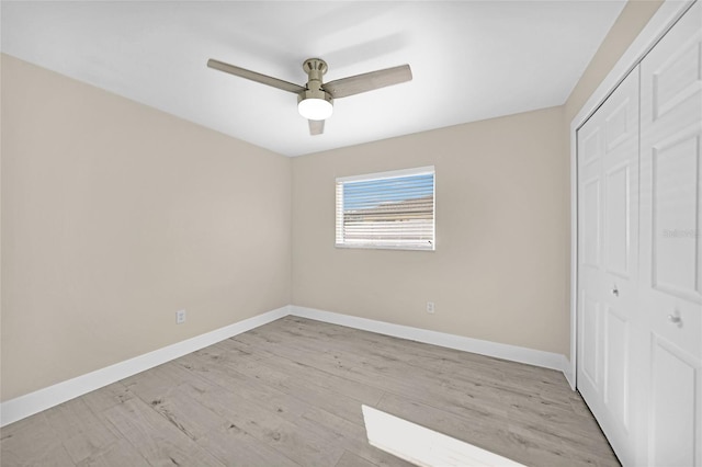 unfurnished bedroom featuring ceiling fan, light wood-type flooring, and a closet