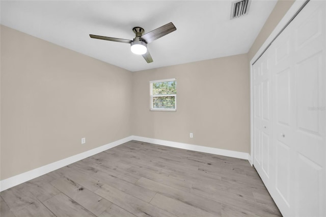 unfurnished bedroom featuring ceiling fan, a closet, and light hardwood / wood-style flooring