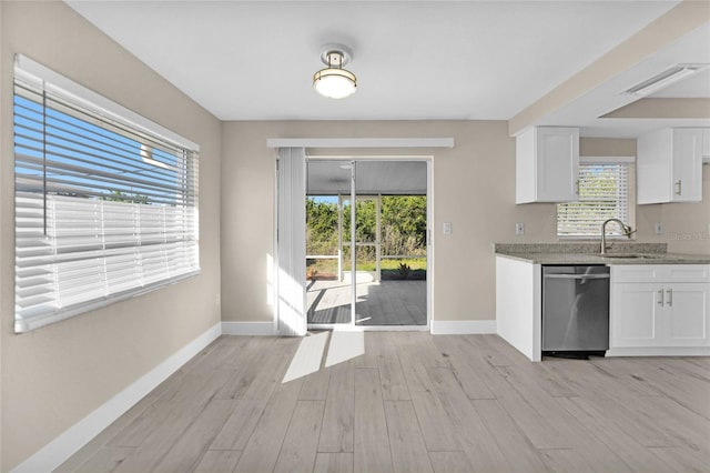 kitchen featuring dishwasher, white cabinets, plenty of natural light, and sink