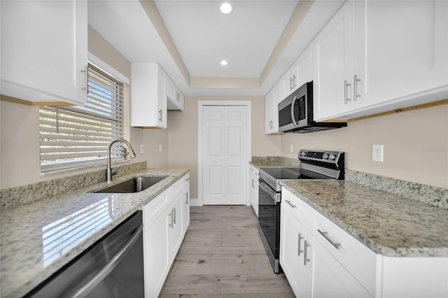 kitchen with white cabinets, light stone counters, sink, and stainless steel appliances