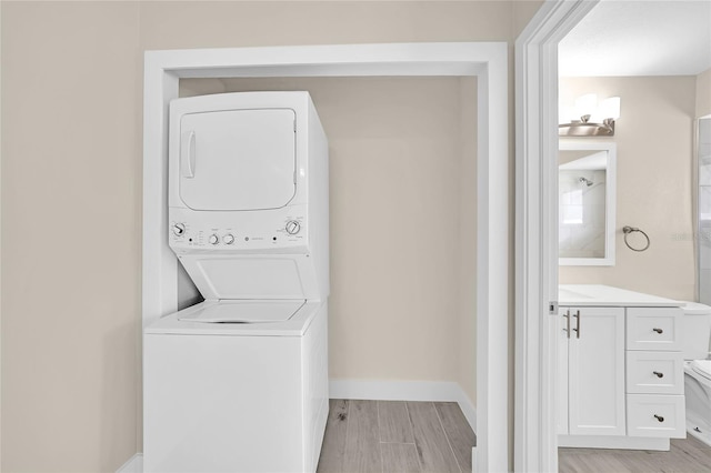 washroom featuring light wood-type flooring and stacked washing maching and dryer