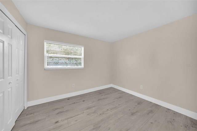 unfurnished bedroom with light hardwood / wood-style flooring and a closet