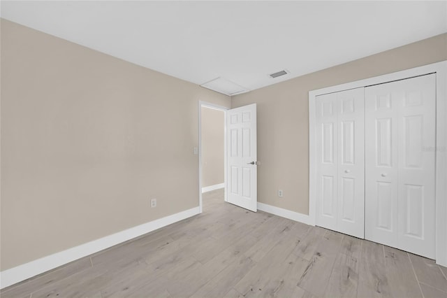 unfurnished bedroom featuring light wood-type flooring and a closet