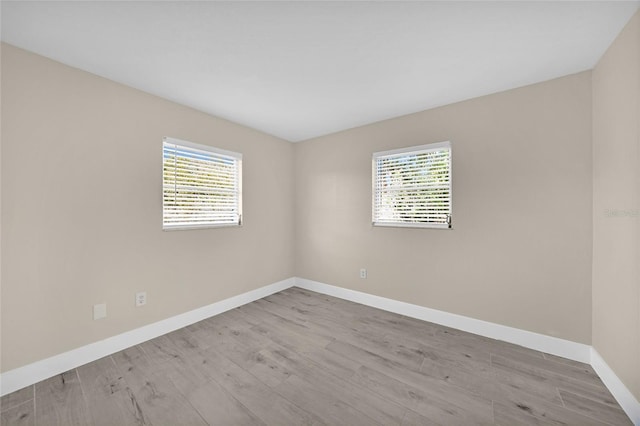 spare room featuring a wealth of natural light and light hardwood / wood-style floors