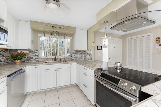 kitchen with tile countertops, stainless steel appliances, and white cabinetry