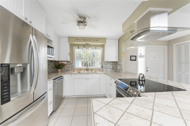 kitchen featuring tile countertops, white cabinets, sink, appliances with stainless steel finishes, and island range hood