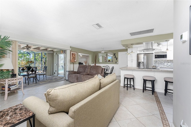 living room with ceiling fan and light tile patterned flooring