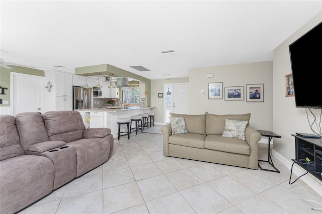 living room featuring ceiling fan and light tile patterned floors