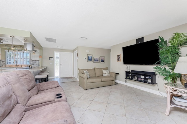 living room featuring sink and light tile patterned floors