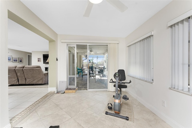 exercise room featuring ceiling fan and light tile patterned flooring