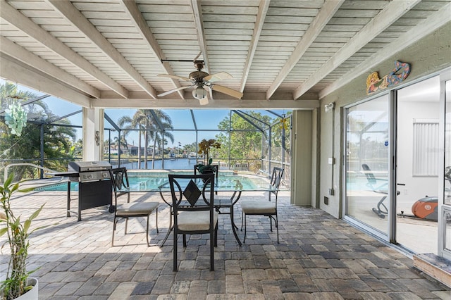 sunroom / solarium with ceiling fan, a water view, and a pool