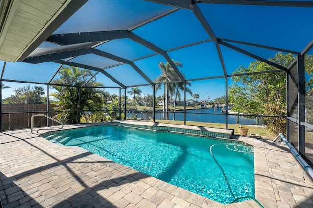 view of pool featuring glass enclosure, a water view, and a patio