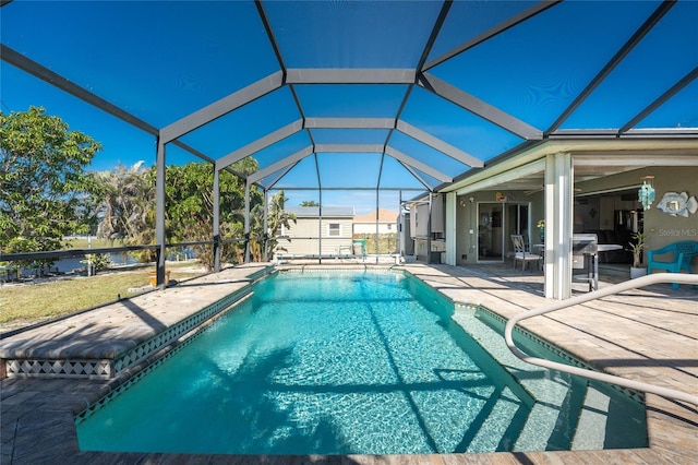 view of pool with glass enclosure and a patio