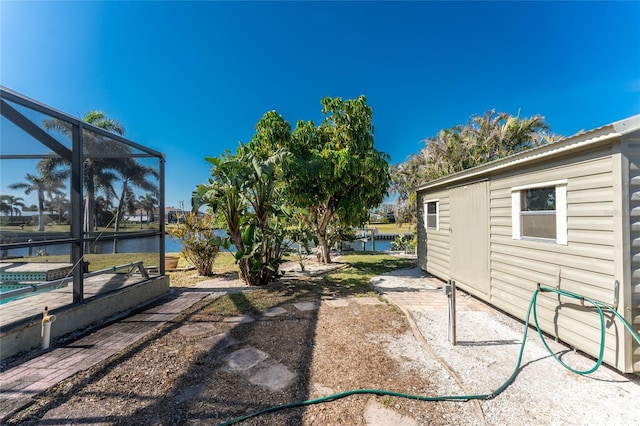 view of yard featuring a lanai and a water view