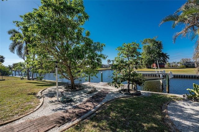 view of front facade featuring a front yard, a boat dock, and a water view