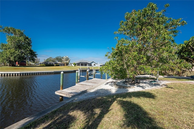 dock area with a water view and a yard