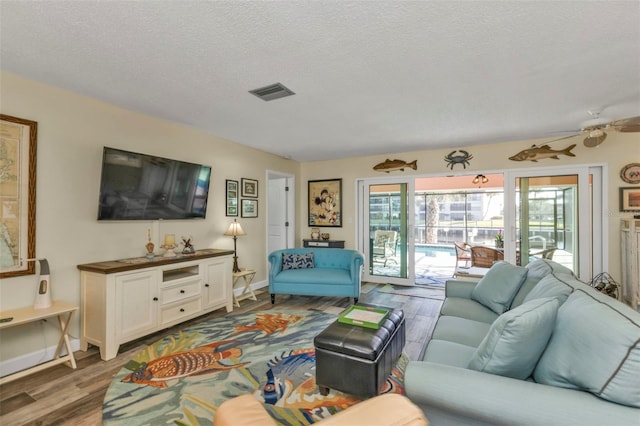 living room with wood-type flooring, a textured ceiling, and ceiling fan