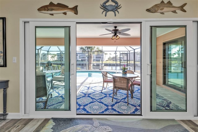 doorway with ceiling fan and hardwood / wood-style flooring