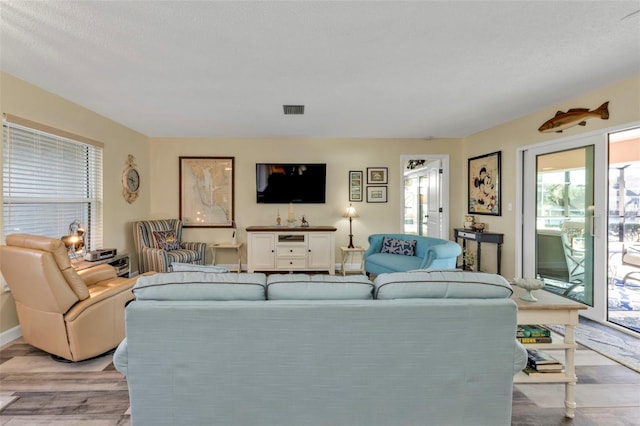 living room featuring a textured ceiling and light wood-type flooring