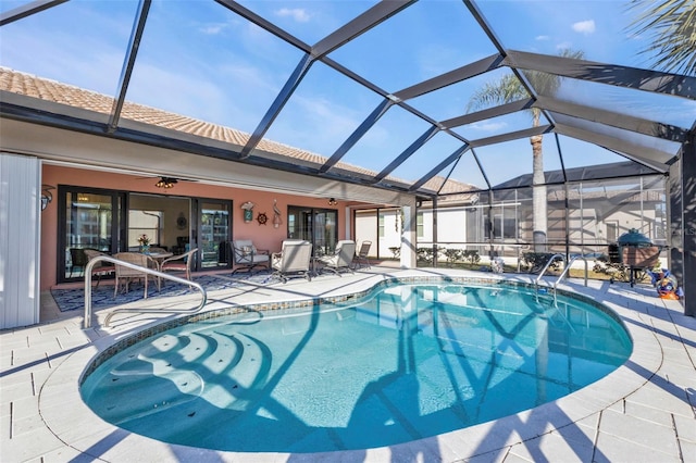 view of pool featuring glass enclosure and a patio area