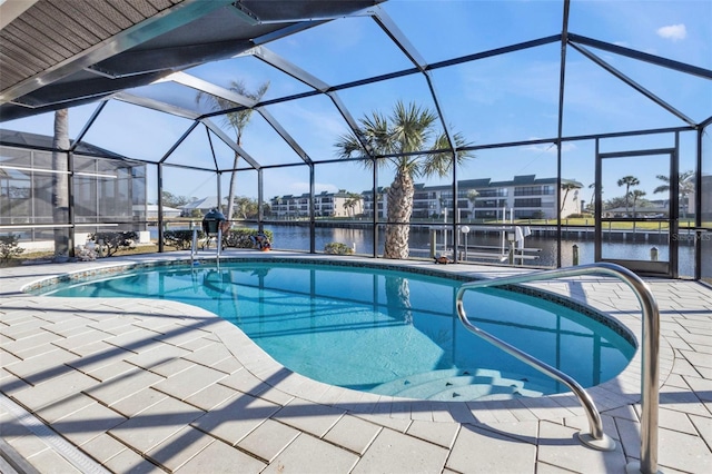 view of swimming pool with glass enclosure, a water view, and a patio