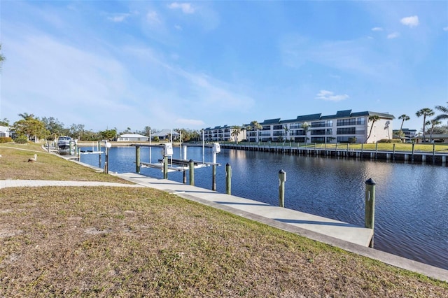 dock area with a water view and a lawn