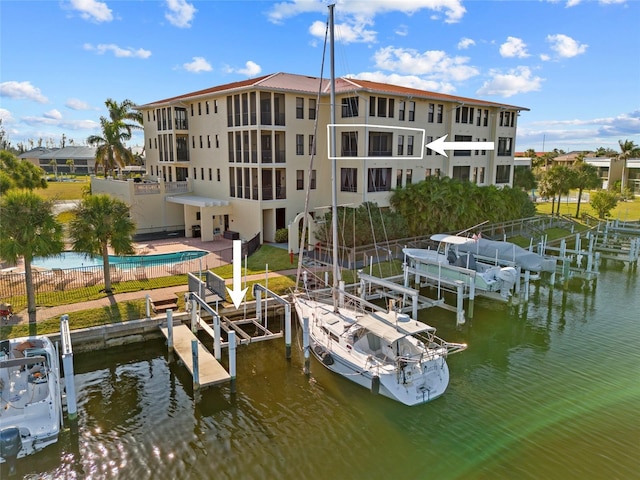 view of dock with a community pool and a water view