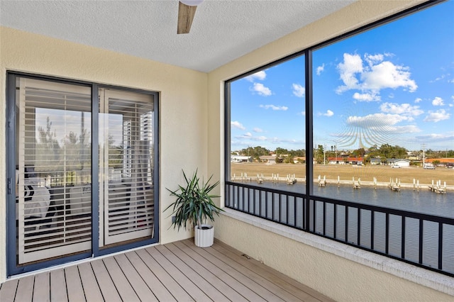 unfurnished sunroom with a water view and ceiling fan