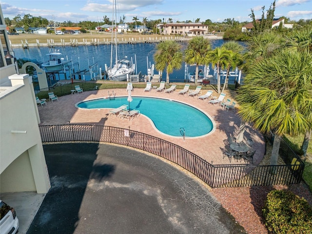 view of swimming pool featuring a water view and a patio